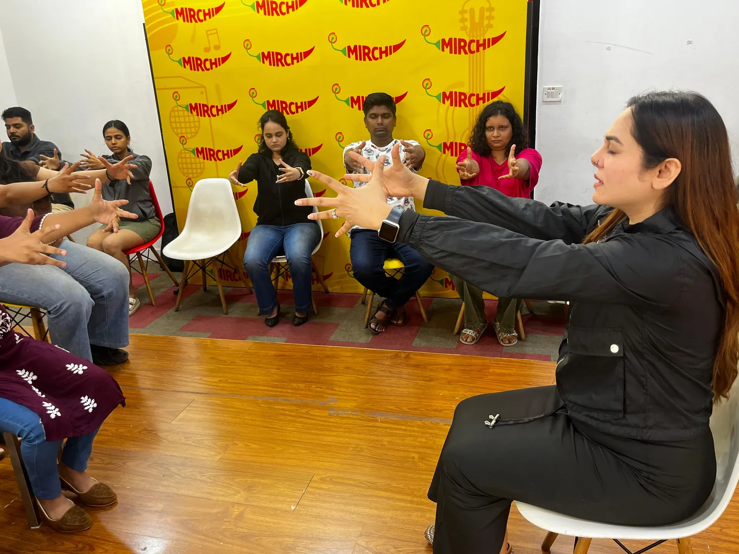 Vibha Jain leading a seated group through a guided relaxation exercise at a workplace session