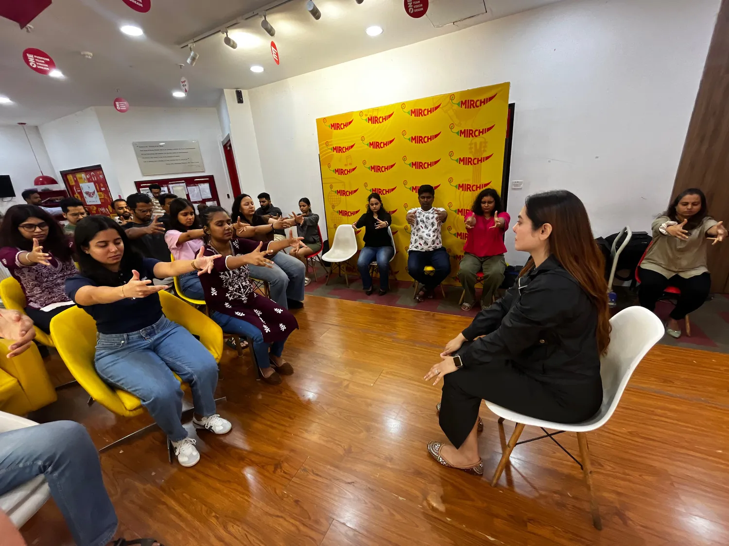 Participants following a guided relaxation exercise during a group workshop led by Vibha Jain