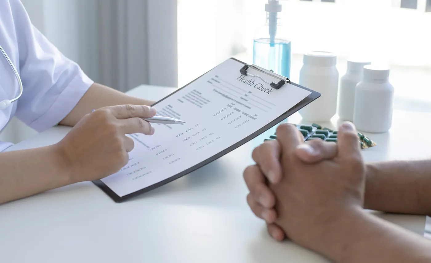 A practitioner discussing notes on a clipboard with a client during a consultation